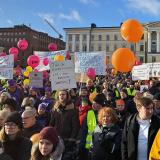 STOP nyt mielenosoituksen osallistujia kylttien ja ilmapallojen kanssa Helsingin Senaatintorilla