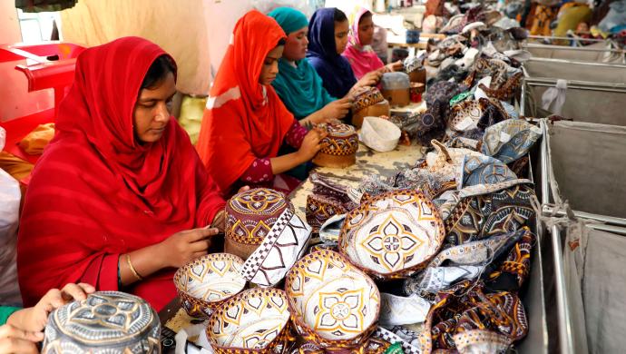 Naiset valmistavat päähineitä bangladeshiläisessä tehtaassa