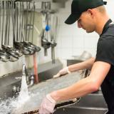 Nuori mies tiskaa ravintolan keittiössä