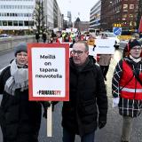 Katja Syvärinen, Jarkko Eloranta ja Annika Rönni-Sällinen ylittämässä Pitkänsillan mielenosoituskyltit kädessään.