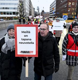 Katja Syvärinen, Jarkko Eloranta ja Annika Rönni-Sällinen ylittämässä Pitkänsillan mielenosoituskyltit kädessään.