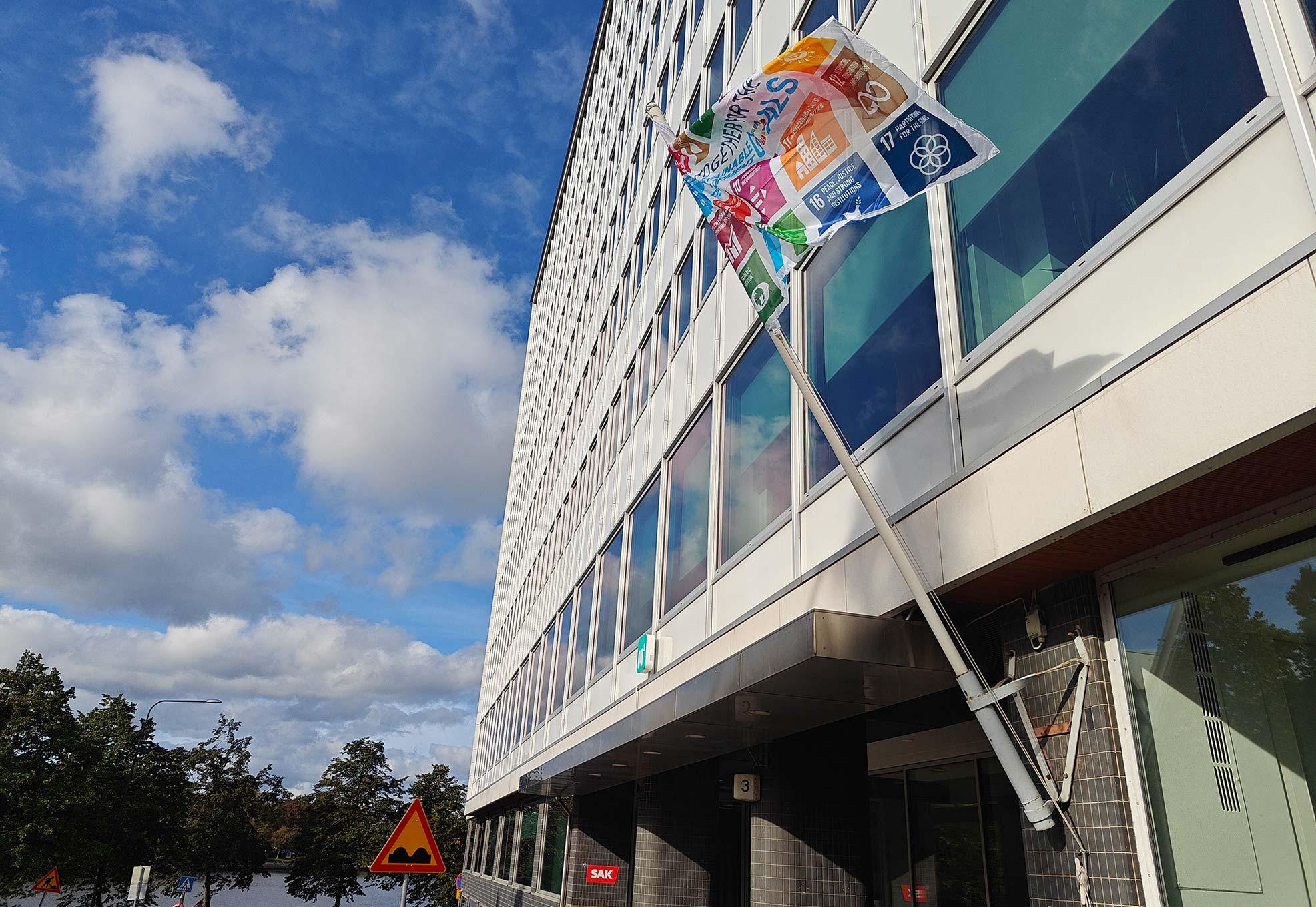 Kestävän kehityksen lippu liehuu SAK:n keskustoimiston edustalla.