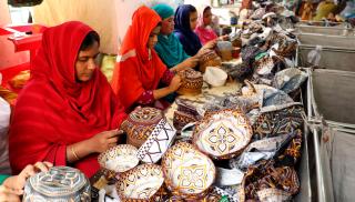 Naiset valmistavat päähineitä bangladeshiläisessä tehtaassa