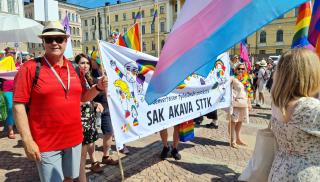 STTK:n puheenjohtaja Antti Palola ja SAK:n sosiaaliasioiden päällikkö Pirjo Väänänen pitelevät SAK:n, STTK:n ja Akavan Pride-banderollia Helsingin Senaatintorilla.