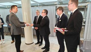 SSAB:n sähkömiesten yhdyshenkilö Jari Korpela luovuttaa SAK:laisten luottamushenkilöiden vetoomuksen hallituspuolueiden eduskuntaryhmien puheenjohtajille eduskunnassa 17.10.2023.