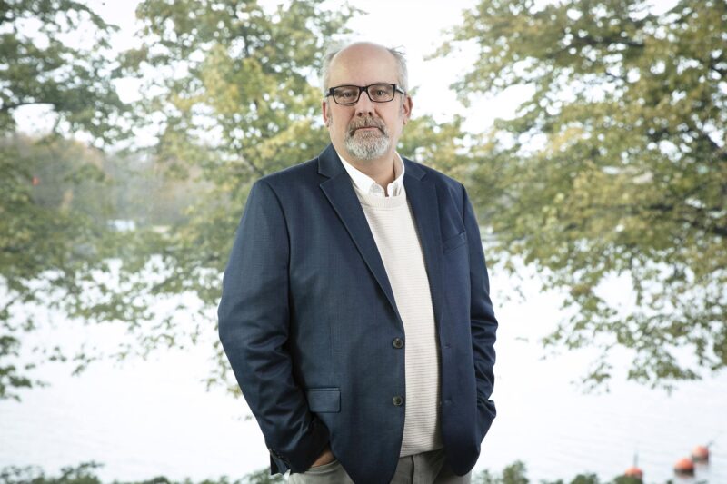 Marko Piirainen seisoo, taustalla merimaisema.