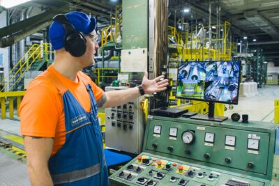 Marko Koivuranta osoittaa kädellään tehtaan valvontalaitetta.