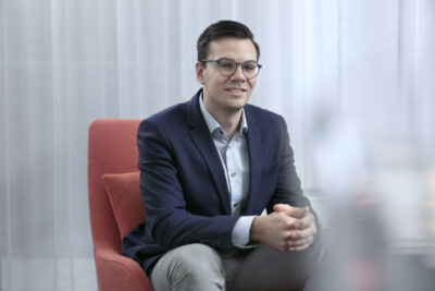 Tatu Knuutila istuu punaisella nojatuolilla.