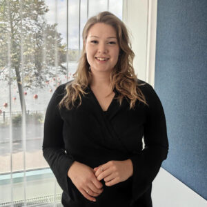 Aurora Ruotsalainen seisoo ison ikkunan edessä.