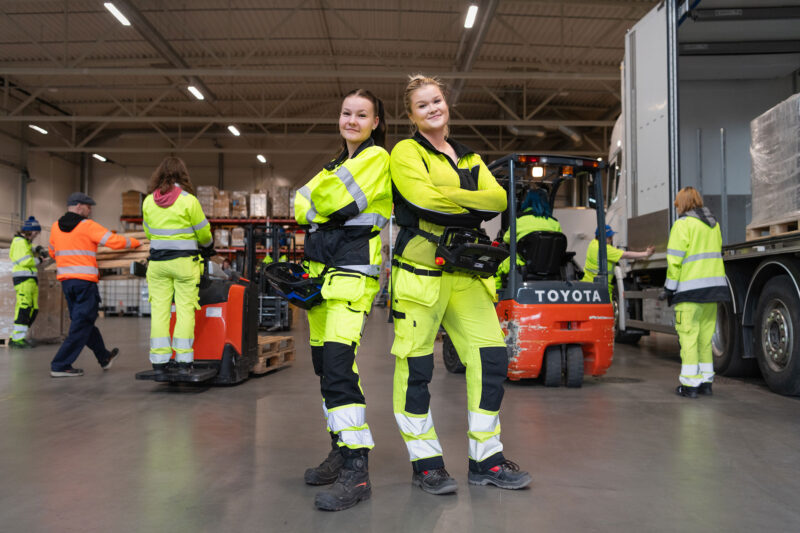 Netta Kinnunen ja Sella Pessa kokovartalokuvassa autohallissa.