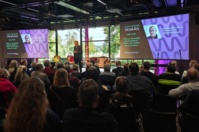 Sixten Korkman seisoo Pikku-Finlandian lavalla ja yleisö kuuntelee hänen puhettaan.