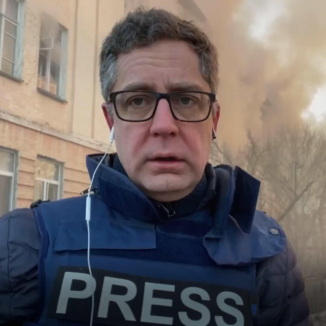 Lähikuva Antti Kurosesta Press-liivi päällä ja savua taustalla.