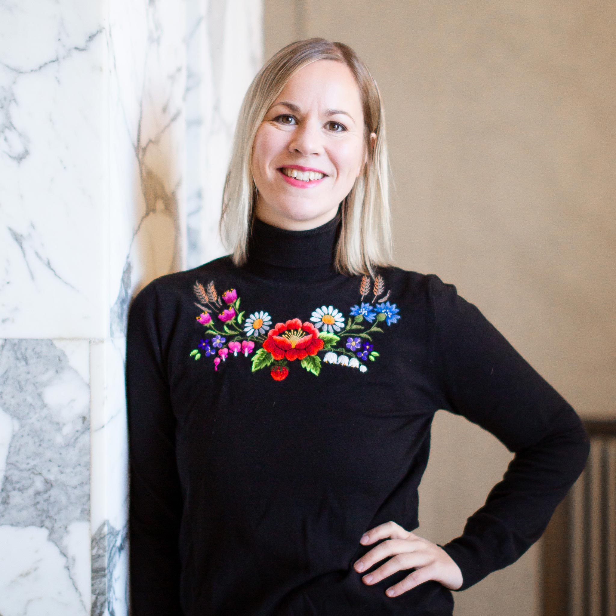 Hanna Sarkkinen nojaa marmorikuvioiseen seinään.