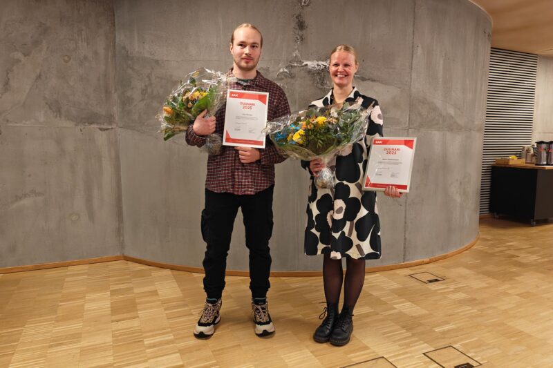 Lassi Becker ja Meri Holmström seisovat vierekkäin kukat ja Vuoden duunari -kunniakirjat käsissään.