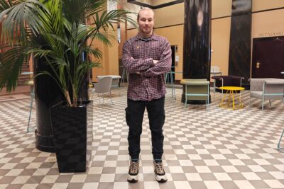 Lassi Becker seisoo ison kirjovehkan vieressä Paasitornin aulassa.