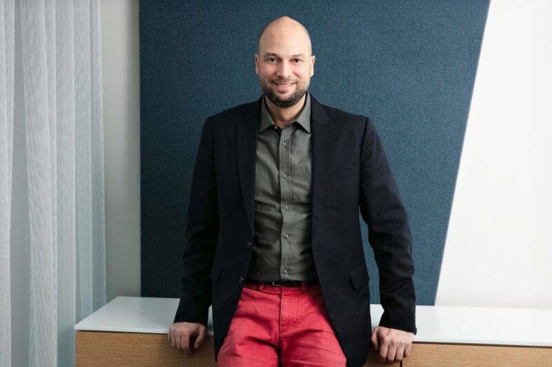 Patrizio Lainà istuu lipaston päällä.