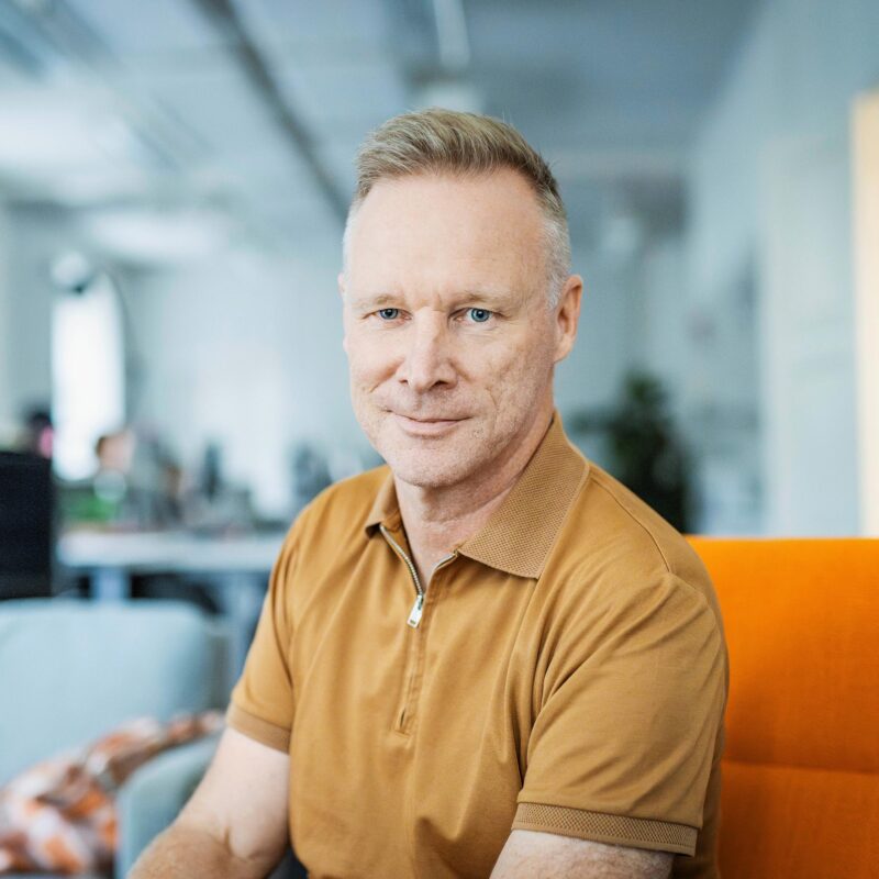 Sami Turunen istuu keltaisella sohvalla.