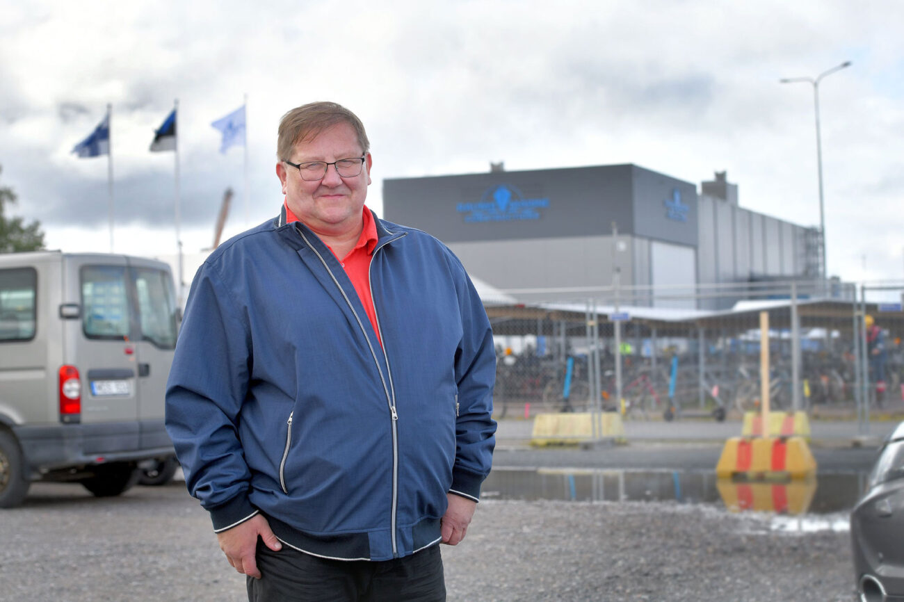 Puolivartalokuva Tapio Koivuniemestä, taustalla telakkarakennus.