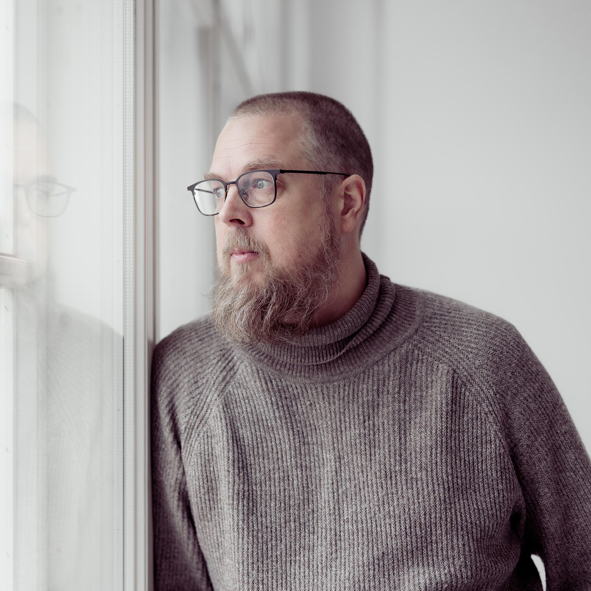 Tuomas Kyrö nojaa ikkunaan ja katsoo ulos.