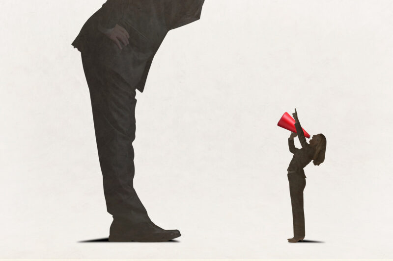 Nainen huutaa megafoniin isommalle mieshahmolle, joka päätä ei näy, mutta hahmo on kumartunut naisen suuntaan.