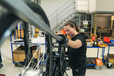 Jenniina Hotti kokoaa polkupyörän runkoa.