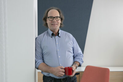 Juha Antila puolivartalokuvassa kahvikuppi kädessä.