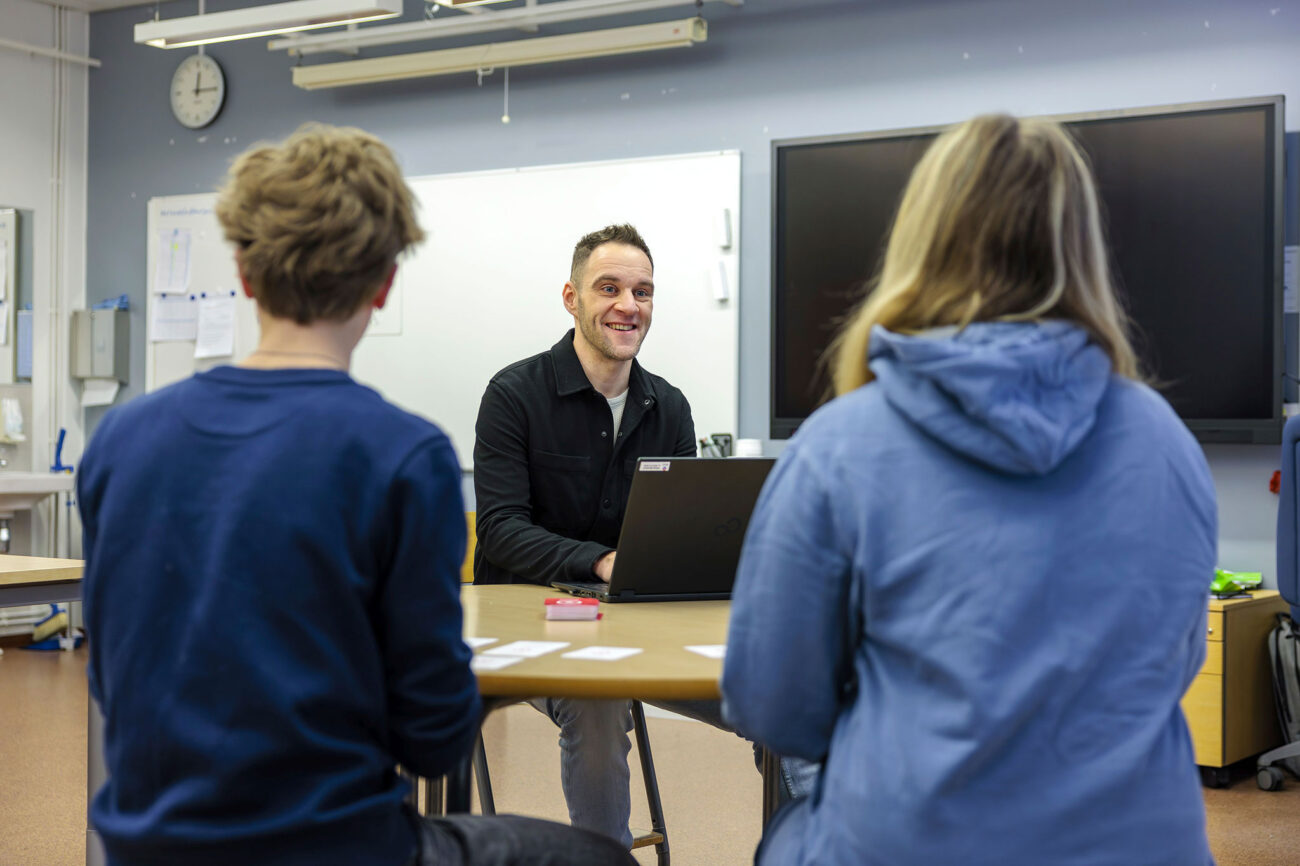 Eero Uotila ja kaksi oppilasta pöydän ääressä.