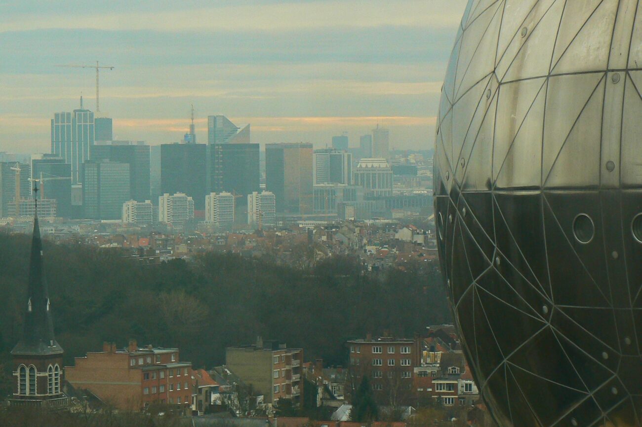 Korkeita kerrostaloja sumun keskellä, etualalla pyöreä metallinen rakennus.