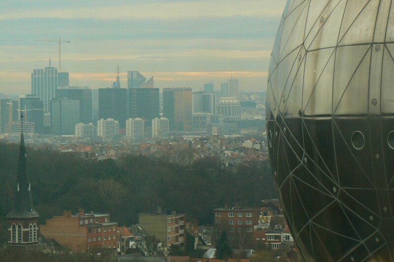 Korkeita kerrostaloja sumun keskellä, etualalla pyöreä metallinen rakennus.