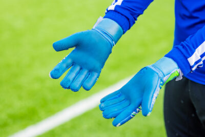 Lähikuva maalivahdin vaaleansinisistä hanskoista.