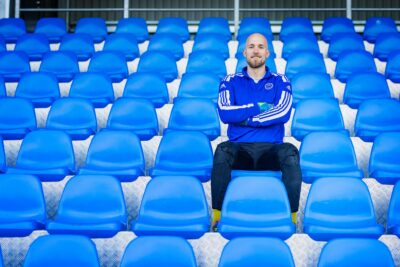 Maalivahti Topi Valtonen istuu jalkapallokatsomon sinisellä kuppituolilla kädet ristissä.