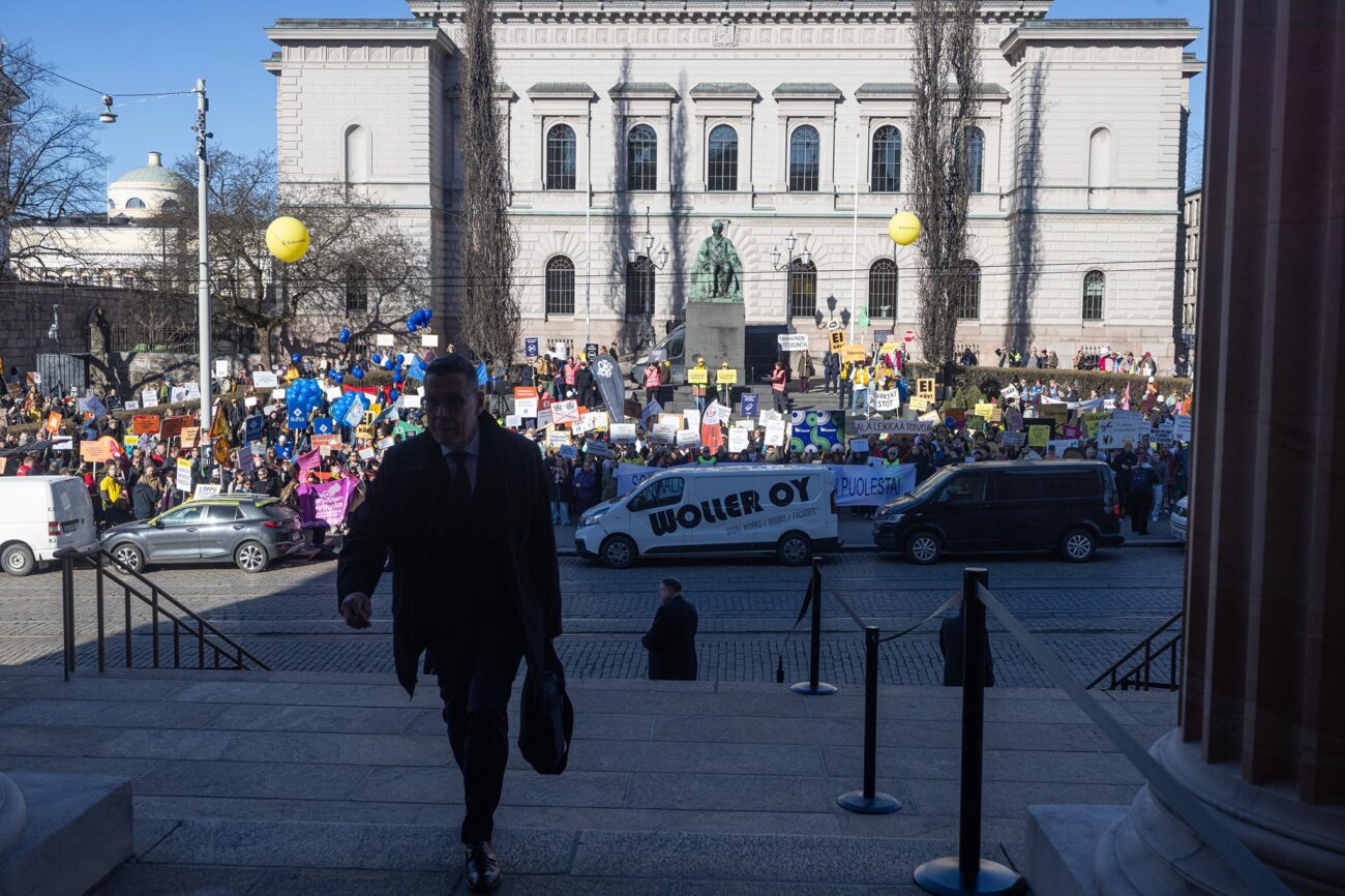 Iso joukko mielenosoittajia vastapäätä Säätytaloa, monilla kädessään jokin kyltti.