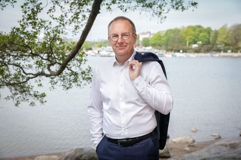 Jarkko Eloranta seisoo meren rannalla pikkutakki heitettynä olan päälle.