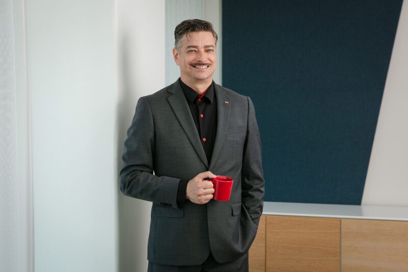 Jyrki Konola seisoo kahvikuppi kädessään.