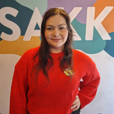 Kia Wilenius seisoo SAKKI ry:n roll upin edessä toinen käsi lanteellaan.