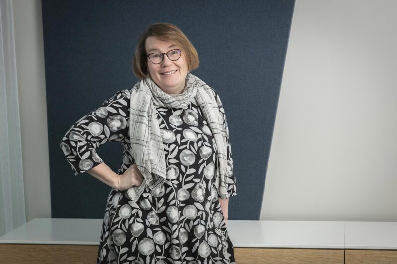 Riitta Työläjärvi seisoo ja nojaa lipastoon.