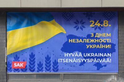 Iso Ukraina-aiheinen banderolli kiinnitettynä ulkoseinään, banderollissa Ukrainan lipun värit keltainen ja sininen, päivämäärä 24.8. ja teksti "Hyvää Ukrainan itsenäisyyspäivää!" ukrainaksi ja suomeksi.